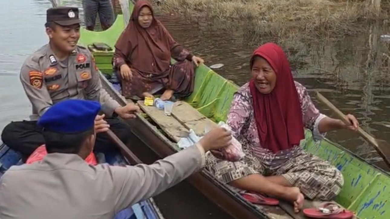 Sambangi Warga yang Terjebak Banjir, Polres Kubar Dayung Perahu Antar Daging Kurban
